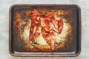 cooked bacon on a baking sheet.