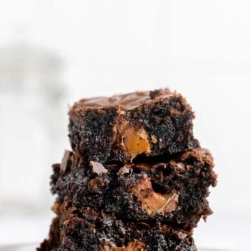 three milky way brownies in a stack on a plate.