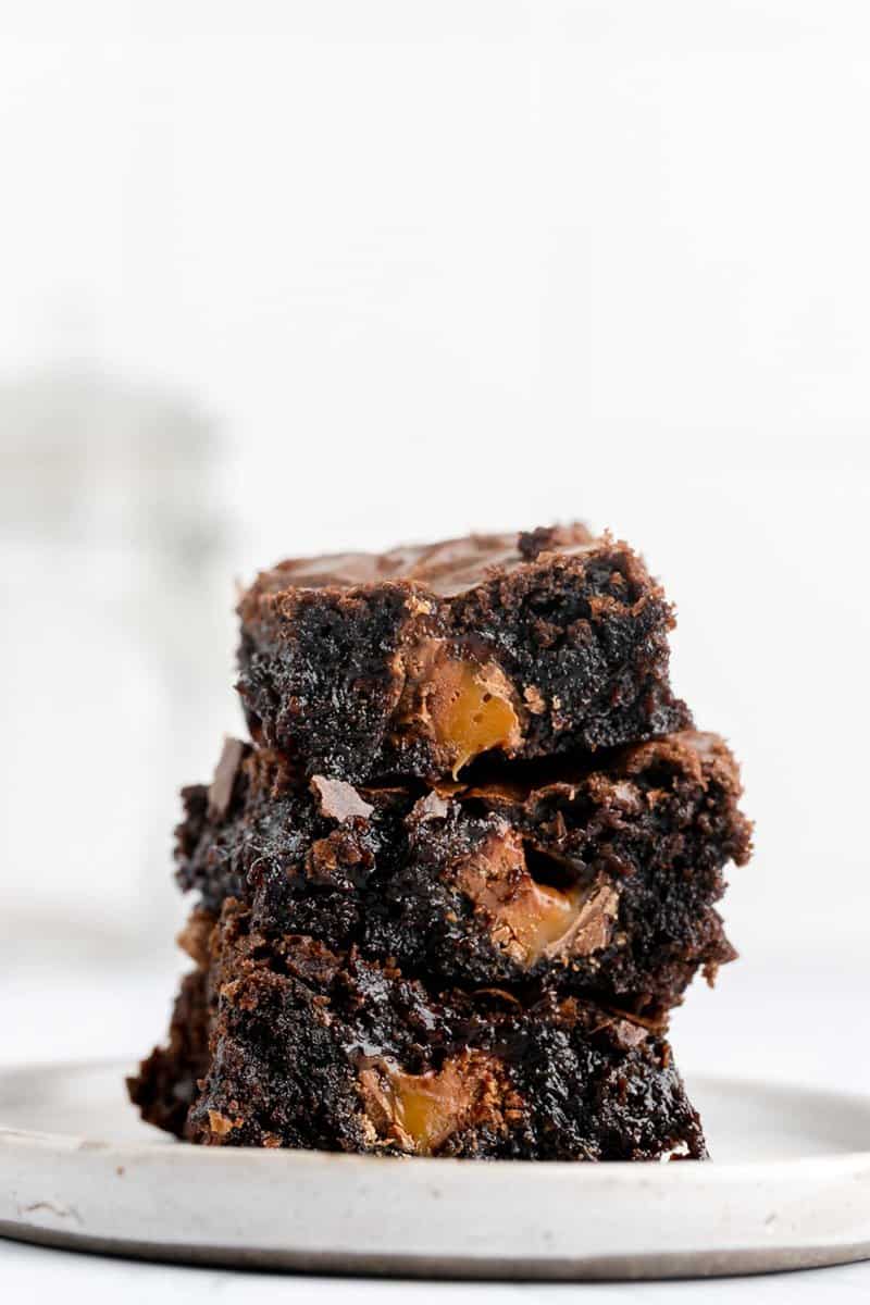 three milky way brownies in a stack on a plate.