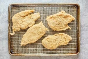 four chicken cutlets breaded with parmesan and Italian breadcrumbs.