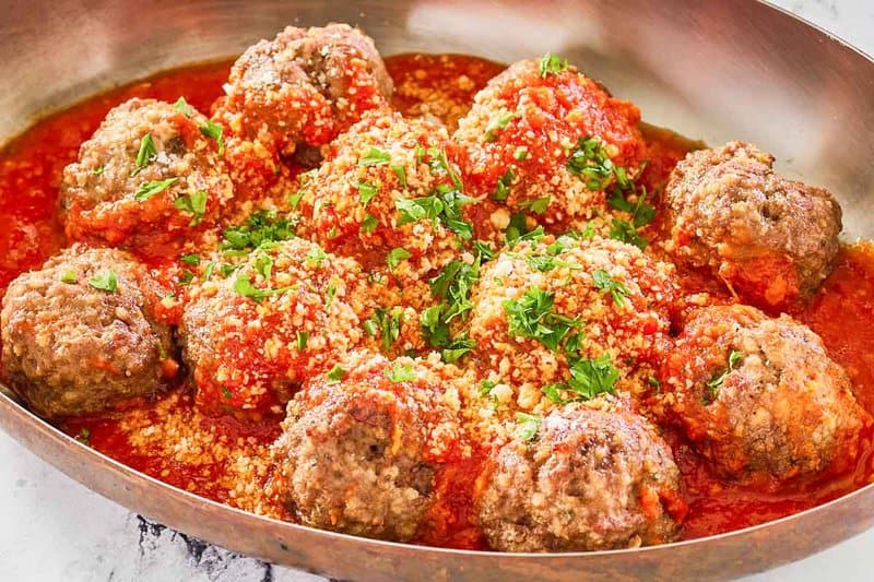 copycat Olive Garden meatballs and marinara sauce in a skillet.