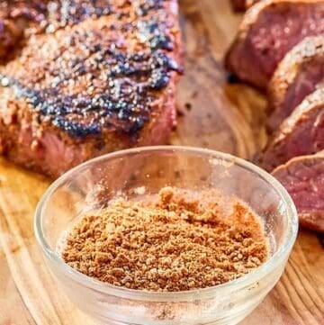 bowl of copycat Outback steak seasoning and two steaks.