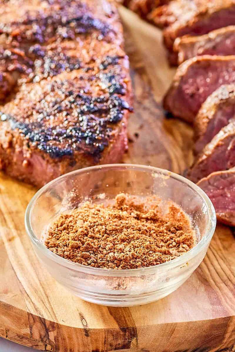 bowl of copycat Outback steak seasoning and two steaks.