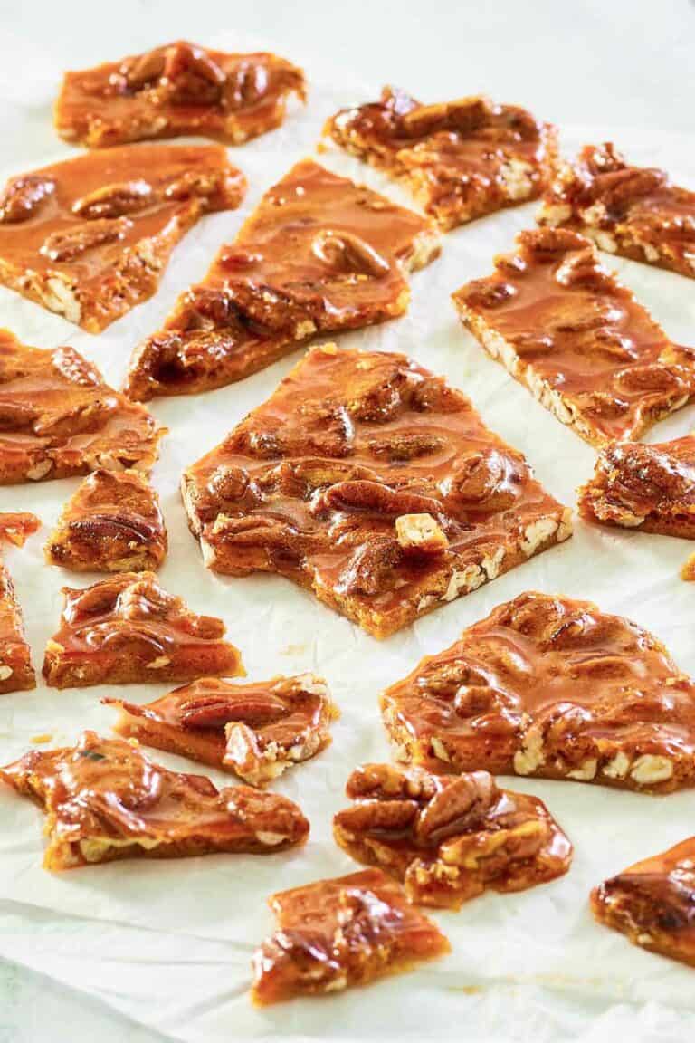 pecan brittle pieces scattered on parchment.