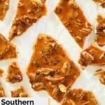 overhead view of pecan brittle pieces on parchment paper.