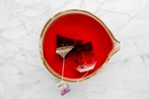 hibiscus and green tea bags steeping in hot water.