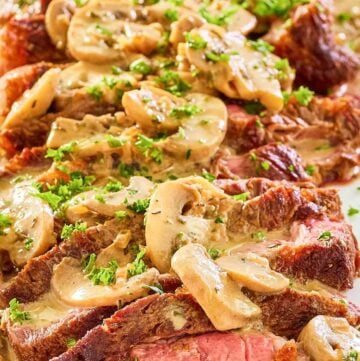 steak marsala with sauce on a white platter.