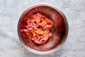 ground beef chuck and seasonings in a bowl.