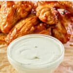 bowl of homemade Wingstop ranch and chicken wings behind it.