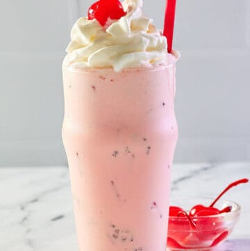 copycat Chick Fil A peppermint milkshake and a bowl of cherries..