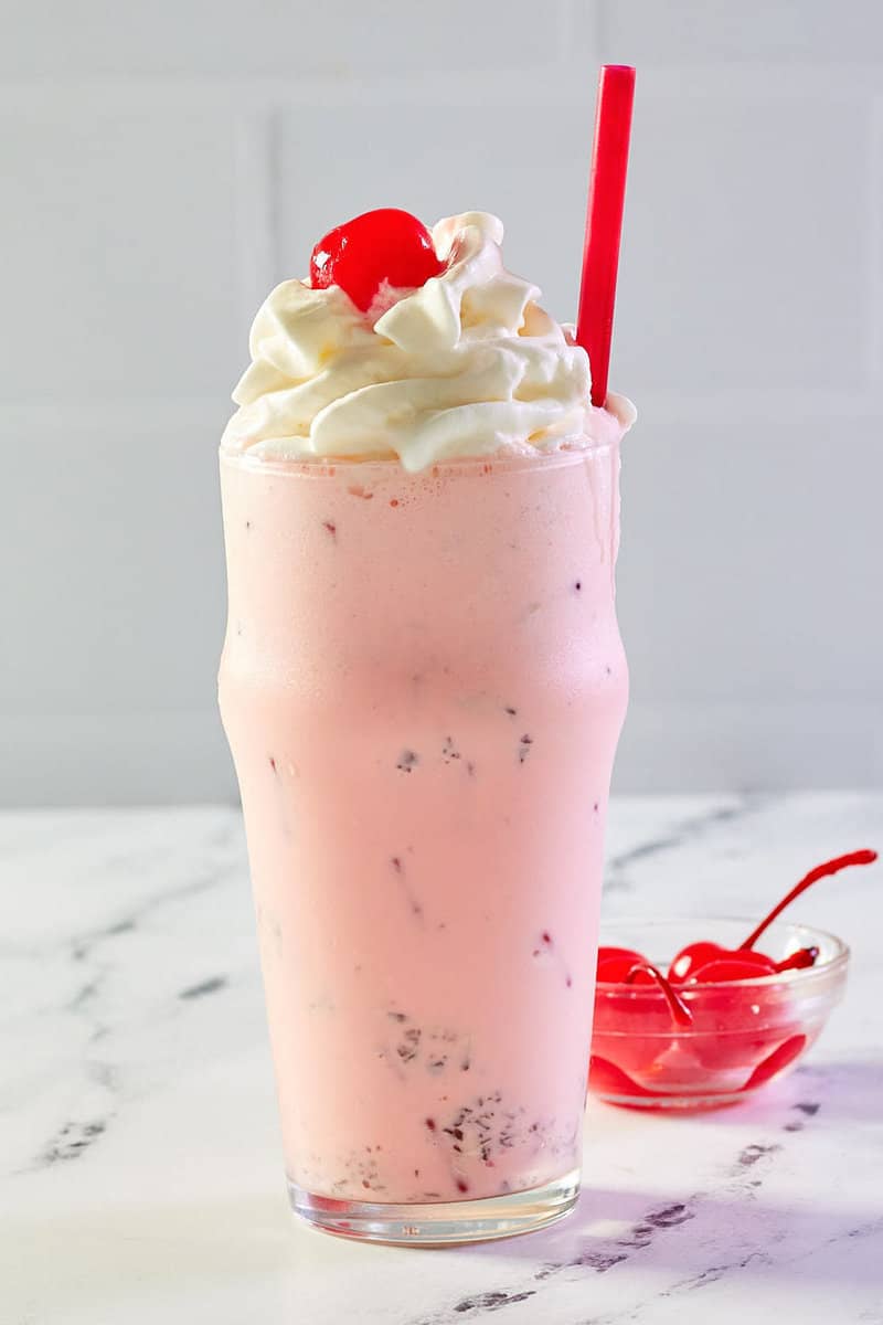 copycat Chick Fil A peppermint milkshake and a bowl of cherries..