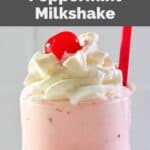 closeup of a homemade chick fil a peppermint chip milkshake with whipped cream and a cherry.