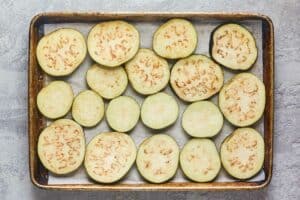 salted eggplant slices on a baking sheet.