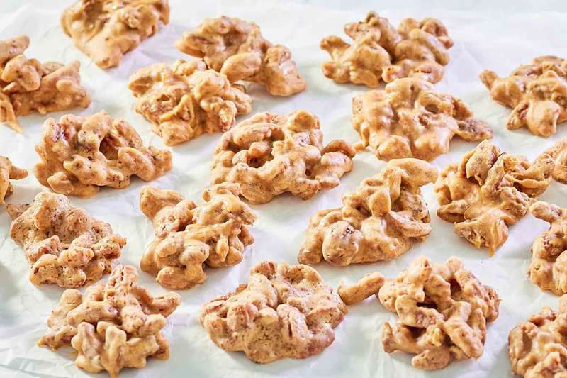 several homemade pecan pralines on parchment paper.