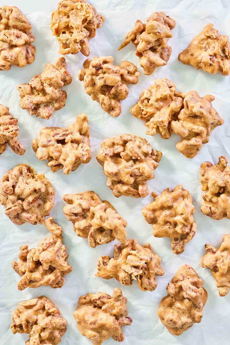 overhead view of homemade pecan pralines on parchment paper.