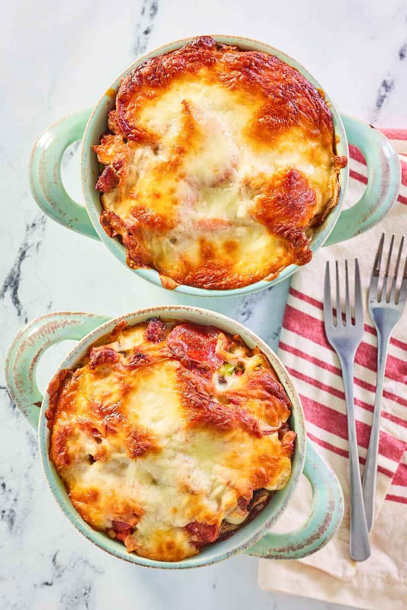 overhead view of pizza bowls with melted mozzarella cheese on top.