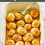 roasted baby potatoes and a serving spoon in a blue baking dish.