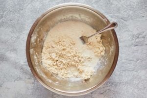 adding wet ingredients to dry ingredients for sweet biscuits.