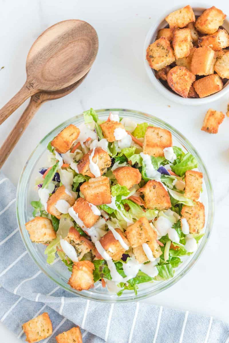 Air fryer croutons in a bowl and on a salad.