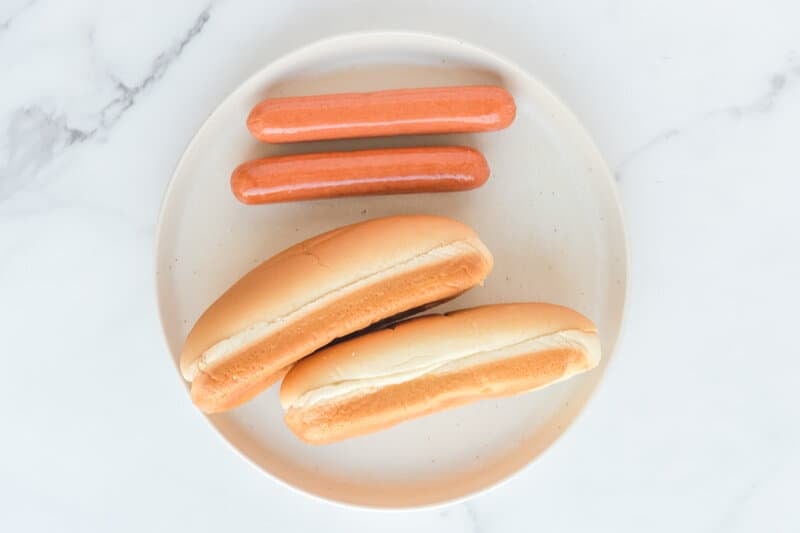 Air fryer hot dogs ingredients on a plate.