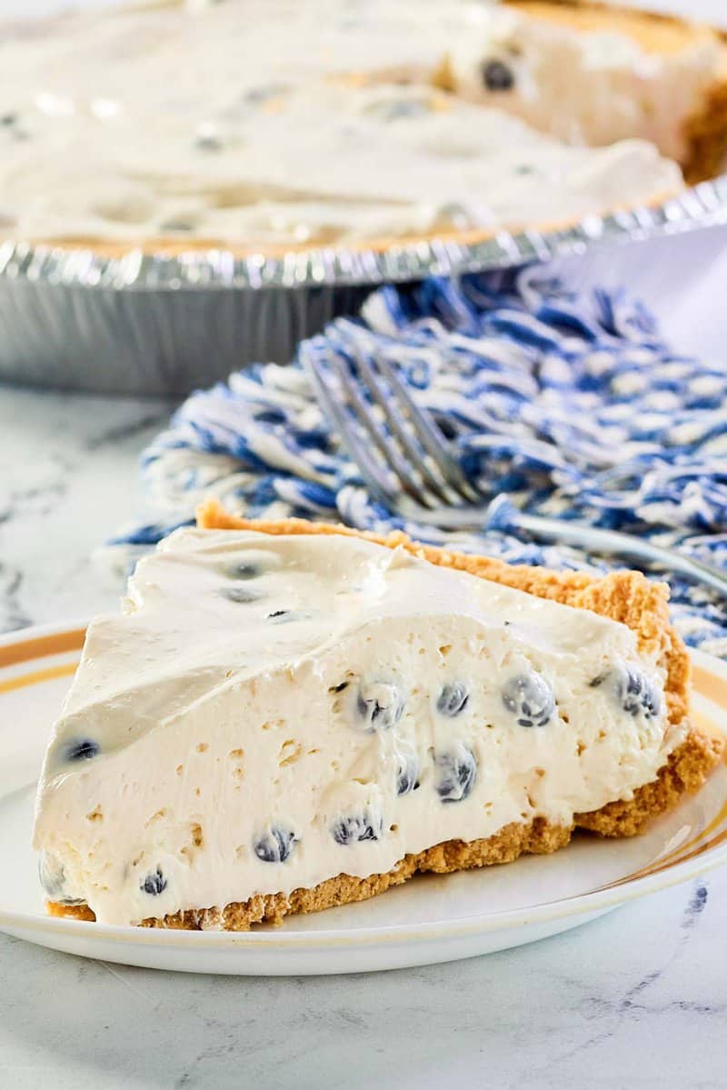 closeup of a slice of blueberry cream pie on a plate.