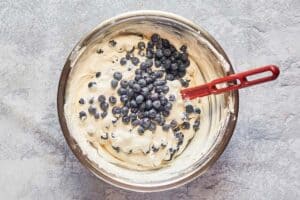 adding fresh blueberries to cream pie filling.