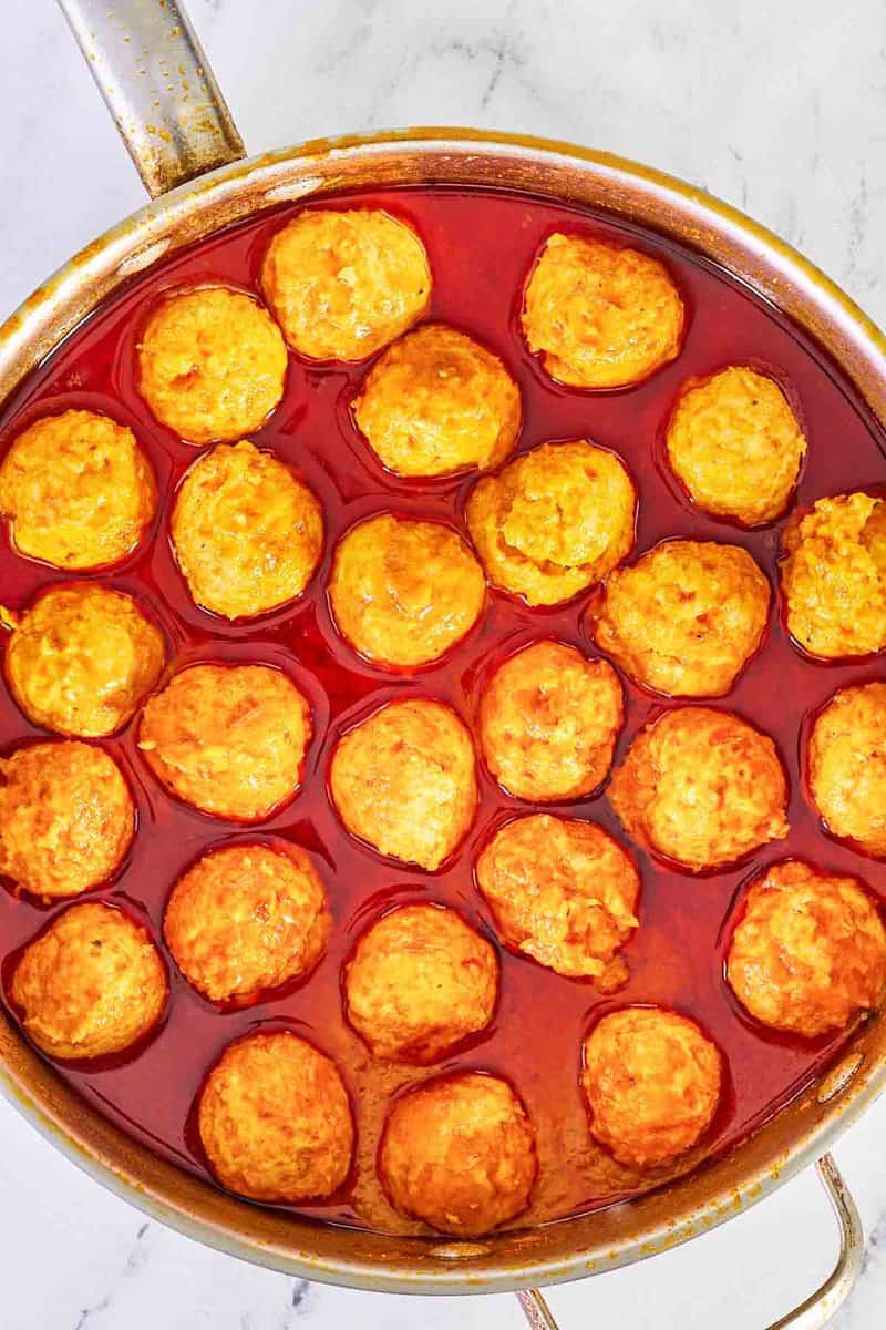 overhead view of Buffalo chicken meatballs and sauce in a pan.