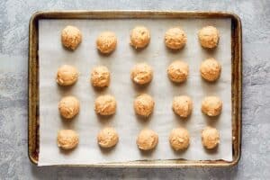 raw chicken meatballs on a baking sheet.