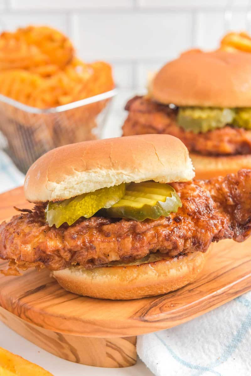 Copycat Chick Fil A spicy chicken sandwich and waffle fries behind it.