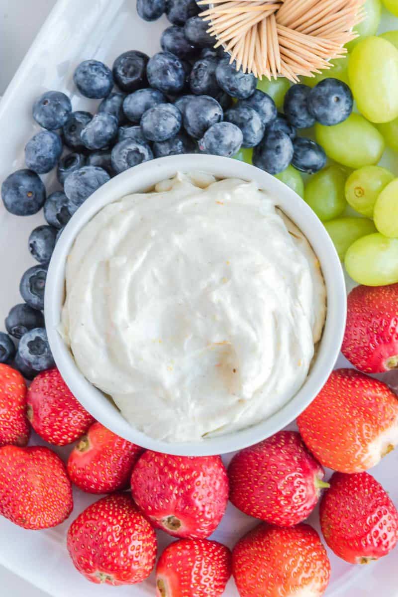 Overhead view of cream cheese fruit dip and fresh fruit on a platter.