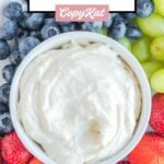 Overhead view of a bowl of cream cheese fruit dip with fruit around it.