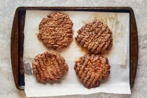 four cooked quarter pound hamburger patties.