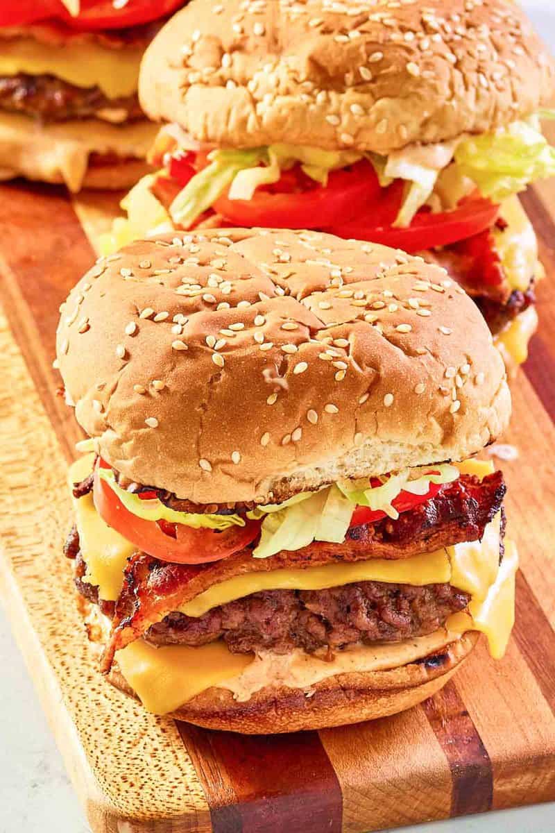 copycat McDonald's smoky BLT quarter pounder with cheese burgers on a wood board.