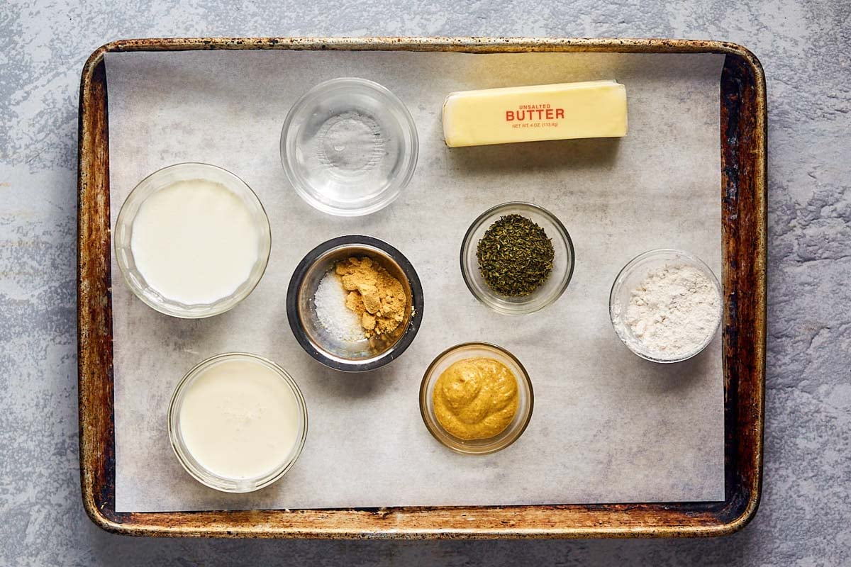 Mustard pick  condiment  ingredients connected  a tray.