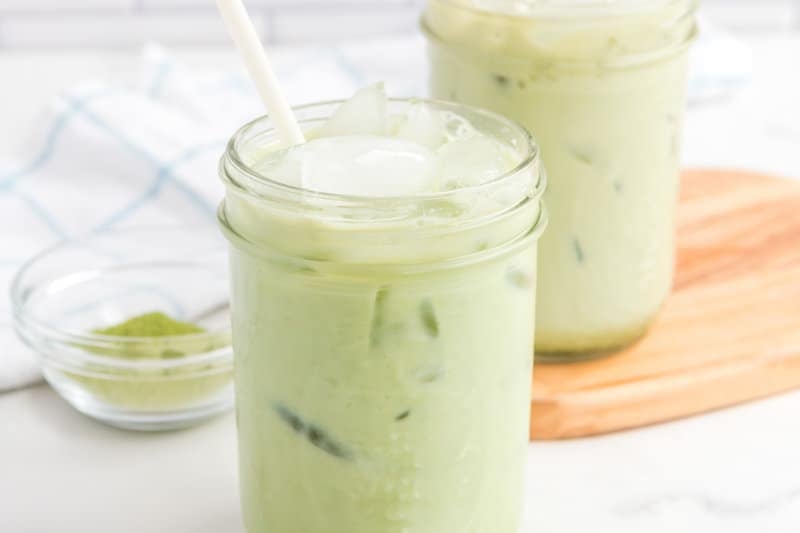 copycat Starbucks iced matcha latte and matcha powder in a small bowl.