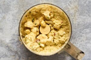 Steamed cauliflower and other ingredients in a food processor.