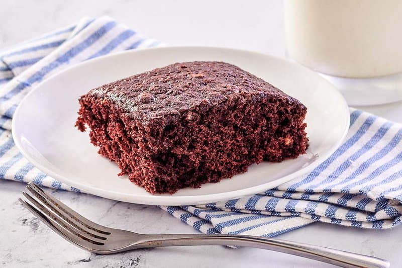 wacky cake slice on a plate on top of a cloth napkin.