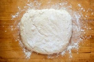 Angel biscuits dough connected  a floured board.