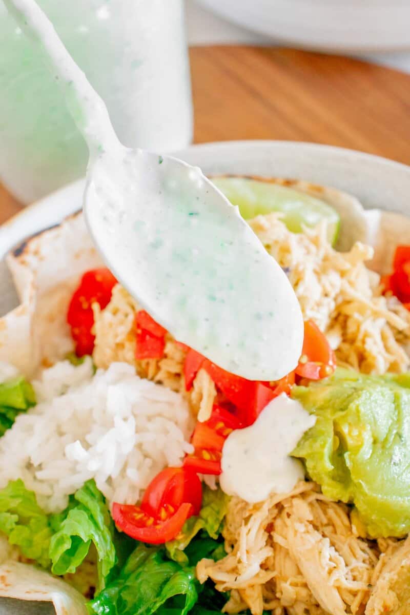A spoonful of tomatillo dressing over a salad.