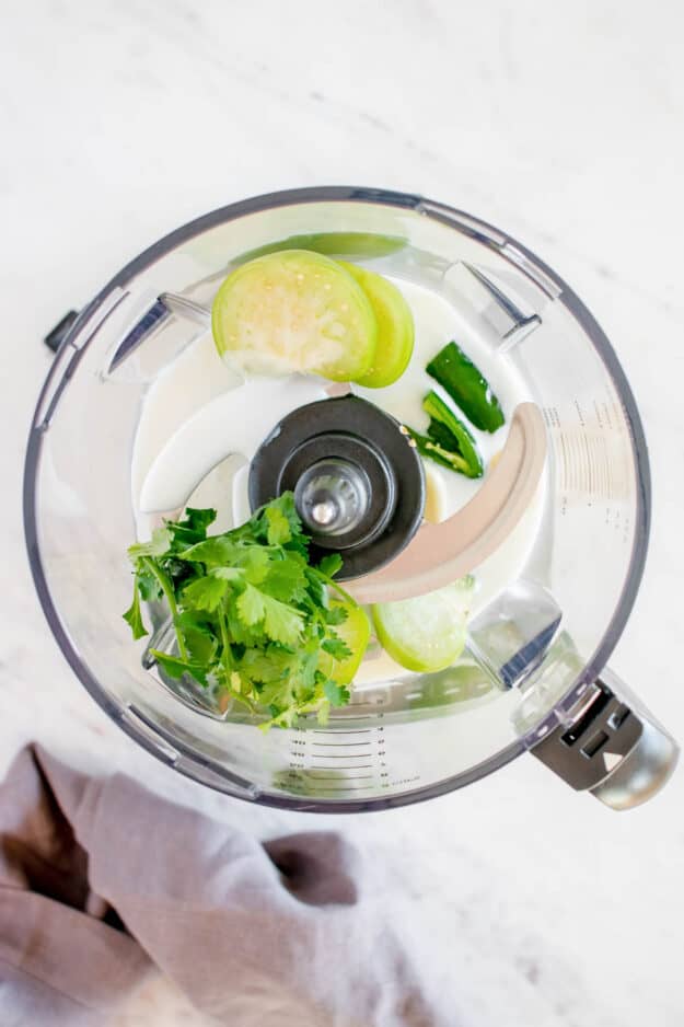 Tomatillo dressing ingredients in a food processor.