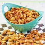 Homemade original chex mix in a bowl and on parchment paper.