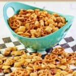Homemade classic chex mix in a bowl and on parchment paper.