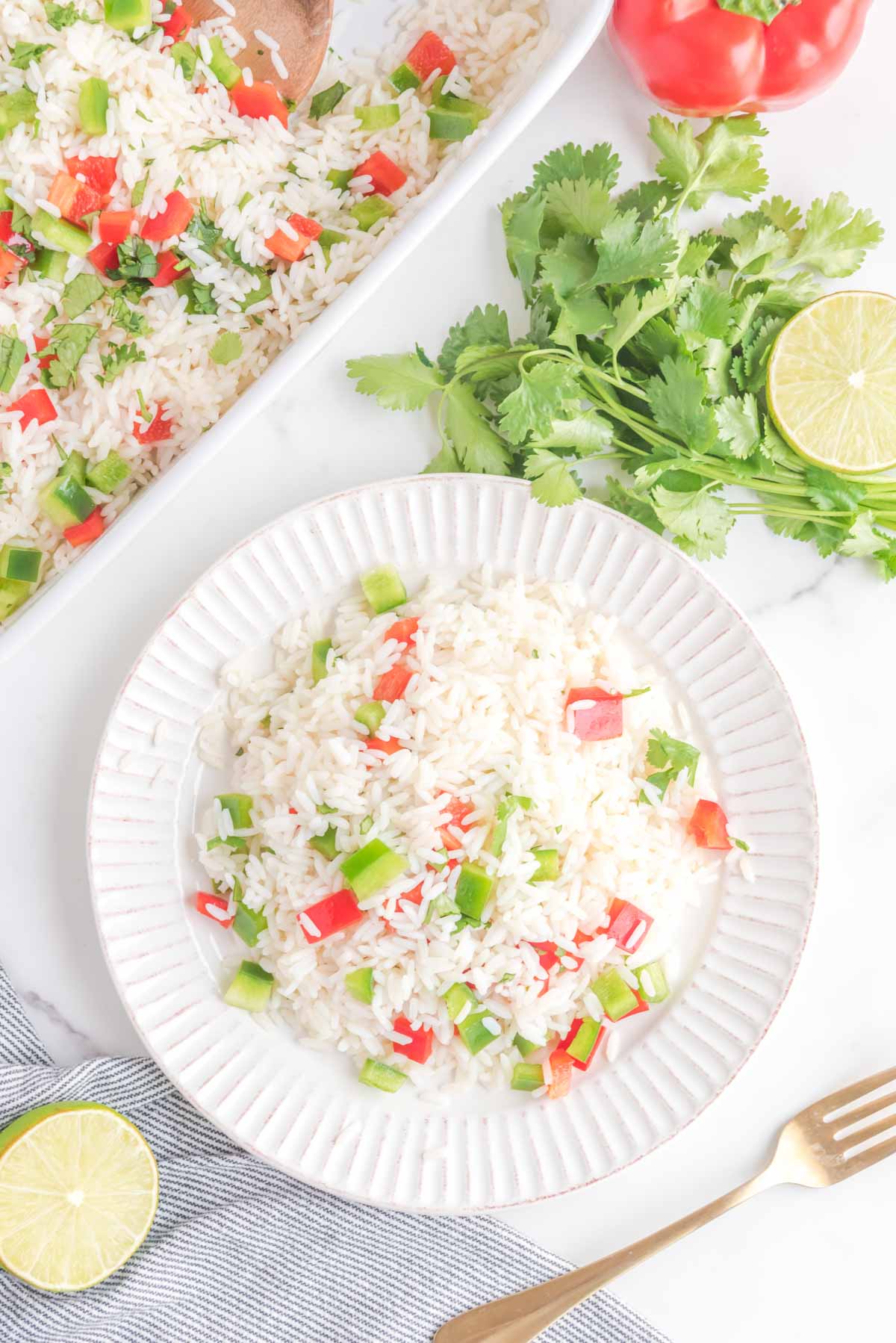 Overhead view of cilantro rice on a plate and in a baking dish.