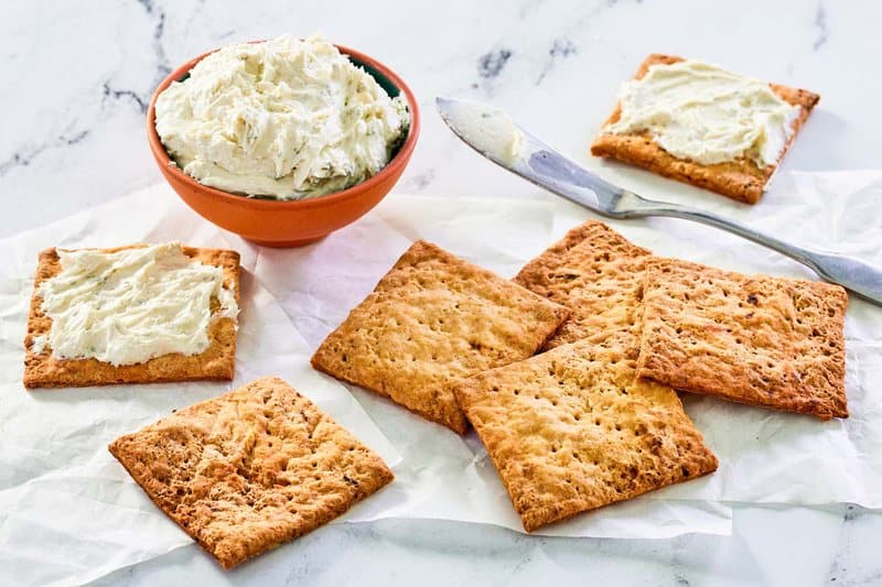 Homemade crackers and two with a cheese spread on them.