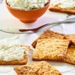 Homemade crackers and a bowl of a cheese spread.