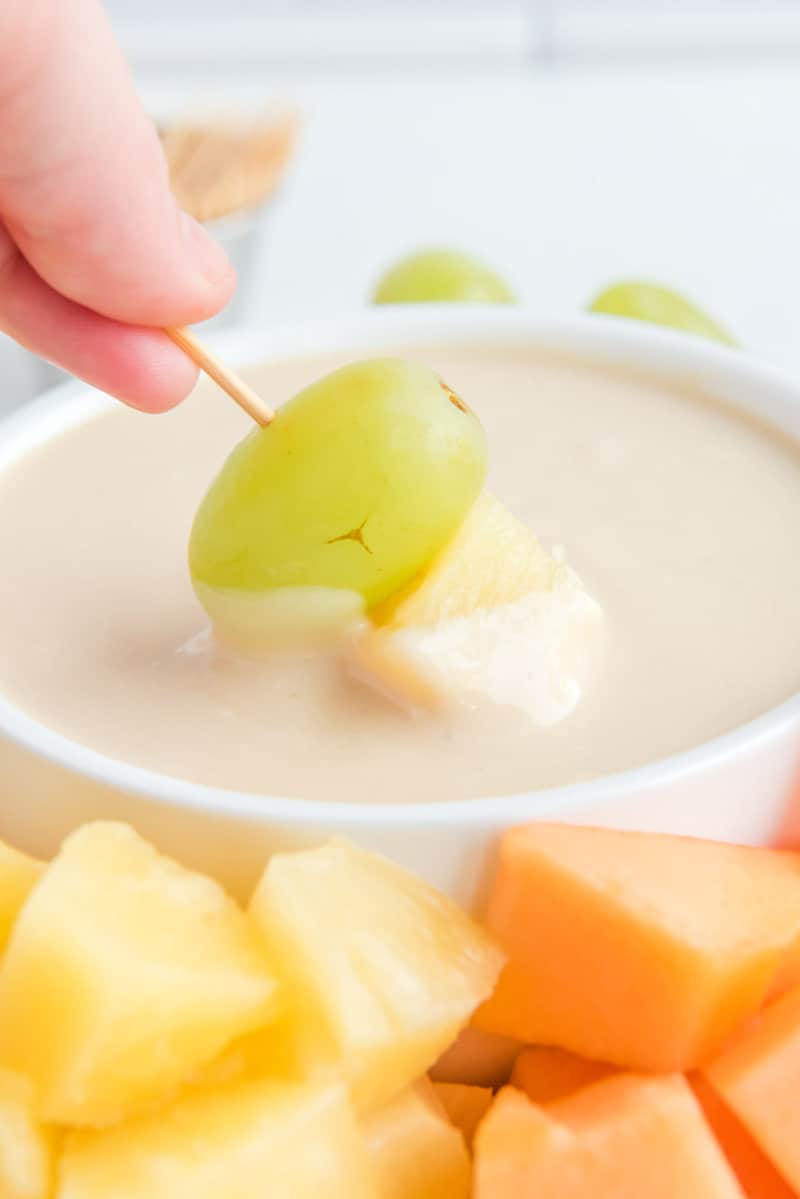 Dipping fruit into copycat Jason's Deli fruit dip.