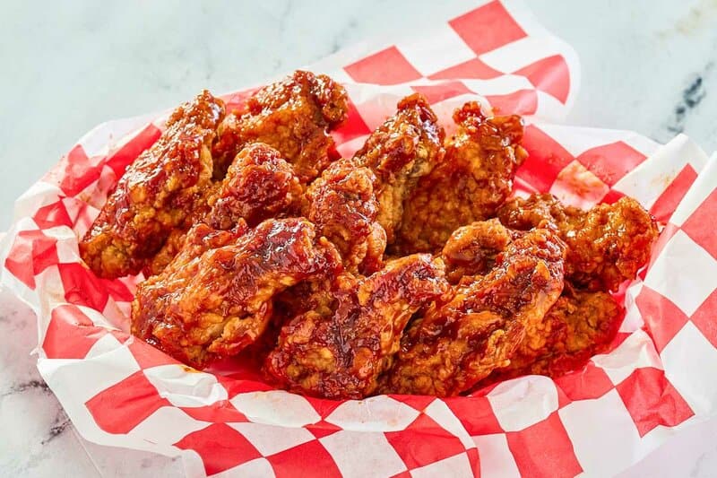 Copycat KFC honey bbq wings on checkered parchment paper.