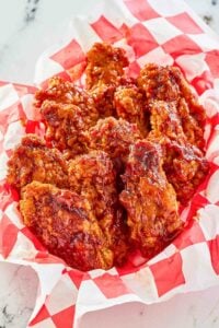 Copycat KFC honey bbq chicken wings in a parchment lined basket.