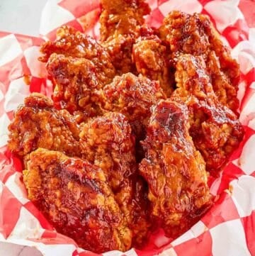 Copycat KFC honey bbq chicken wings in a parchment lined basket.