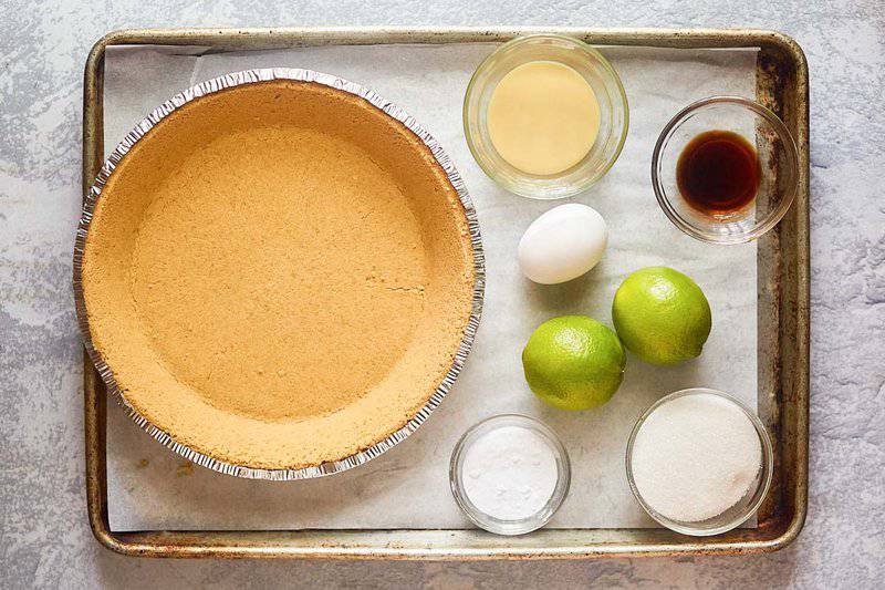 Key lime pie with meringue ingredients on a tray.